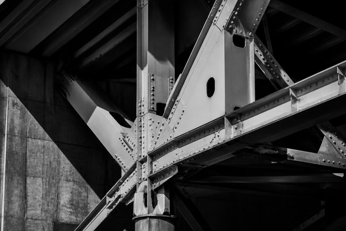 High-contrast architectural detail of a steel bridge girder system